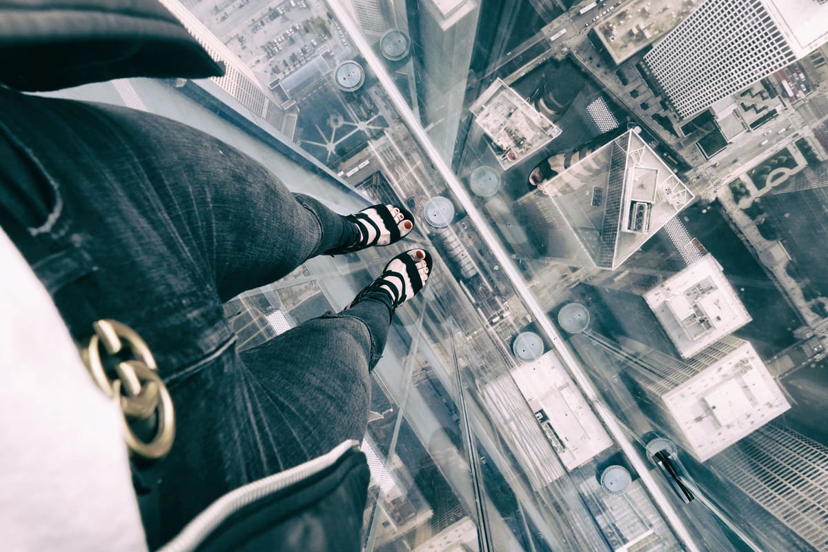 Vue plongeante depuis un sol en verre au sommet d'un immeuble, sensation de vertige