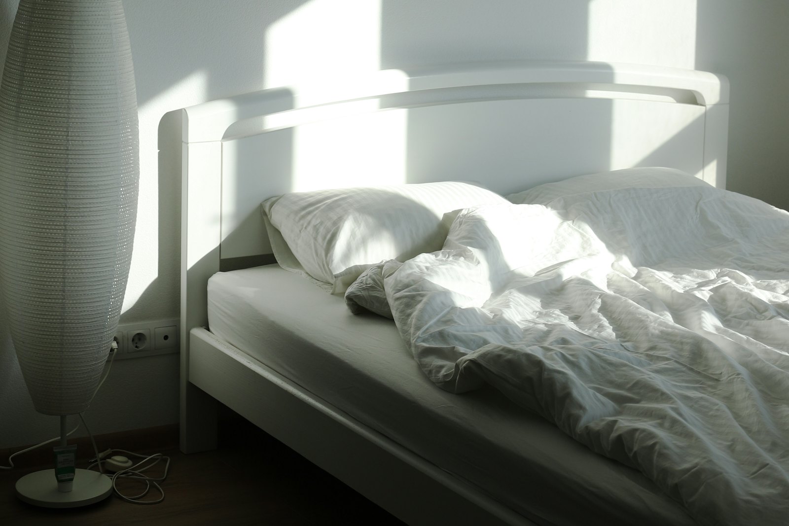 Chambre calme baignée de lumière du matin, lit défait